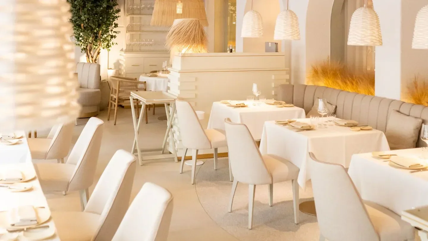 Elegant interior of Areia restaurant in Marbella with stylish white decor and seating.