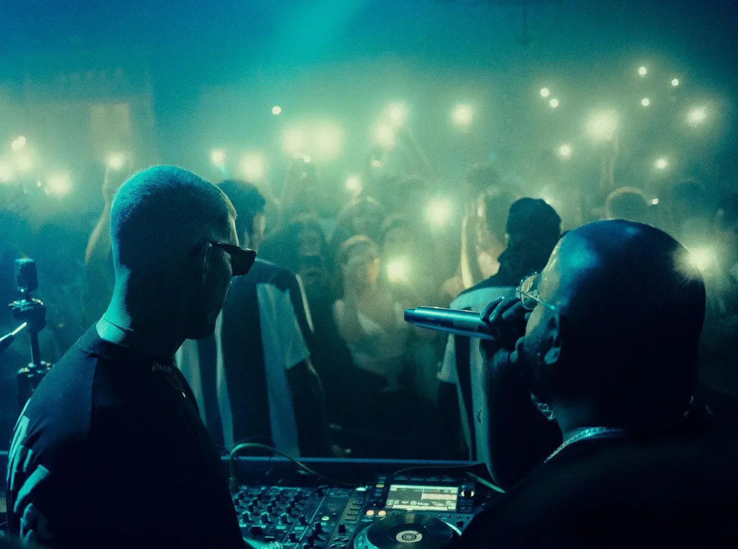 DJ performance at BANDO Arts Club in Marbella, with crowd illuminated by phone lights.