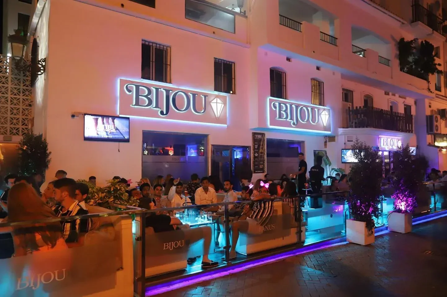 Exterior view of Bijou Banus nightclub in Marbella at night with people gathered.