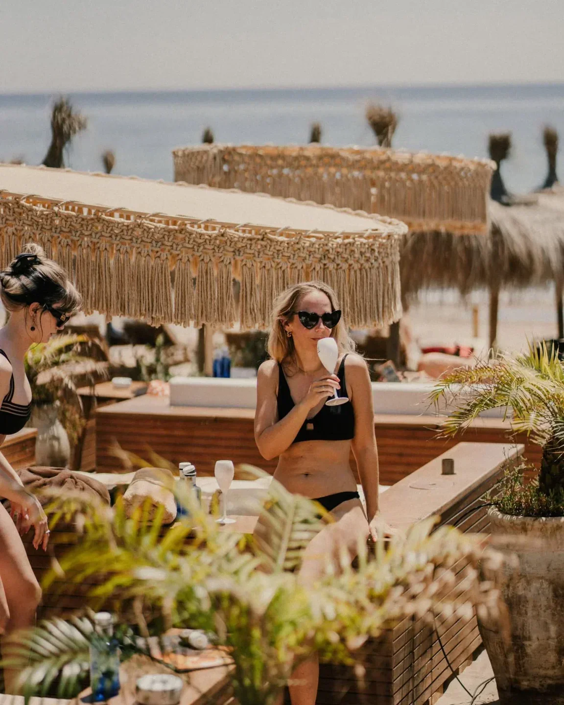 Enjoying drinks at Bono Beach in Marbella with stylish beach umbrellas and decor.