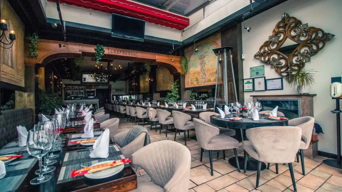Elegant interior of Carpaccio restaurant in Marbella, Spain, with tables set for dining.