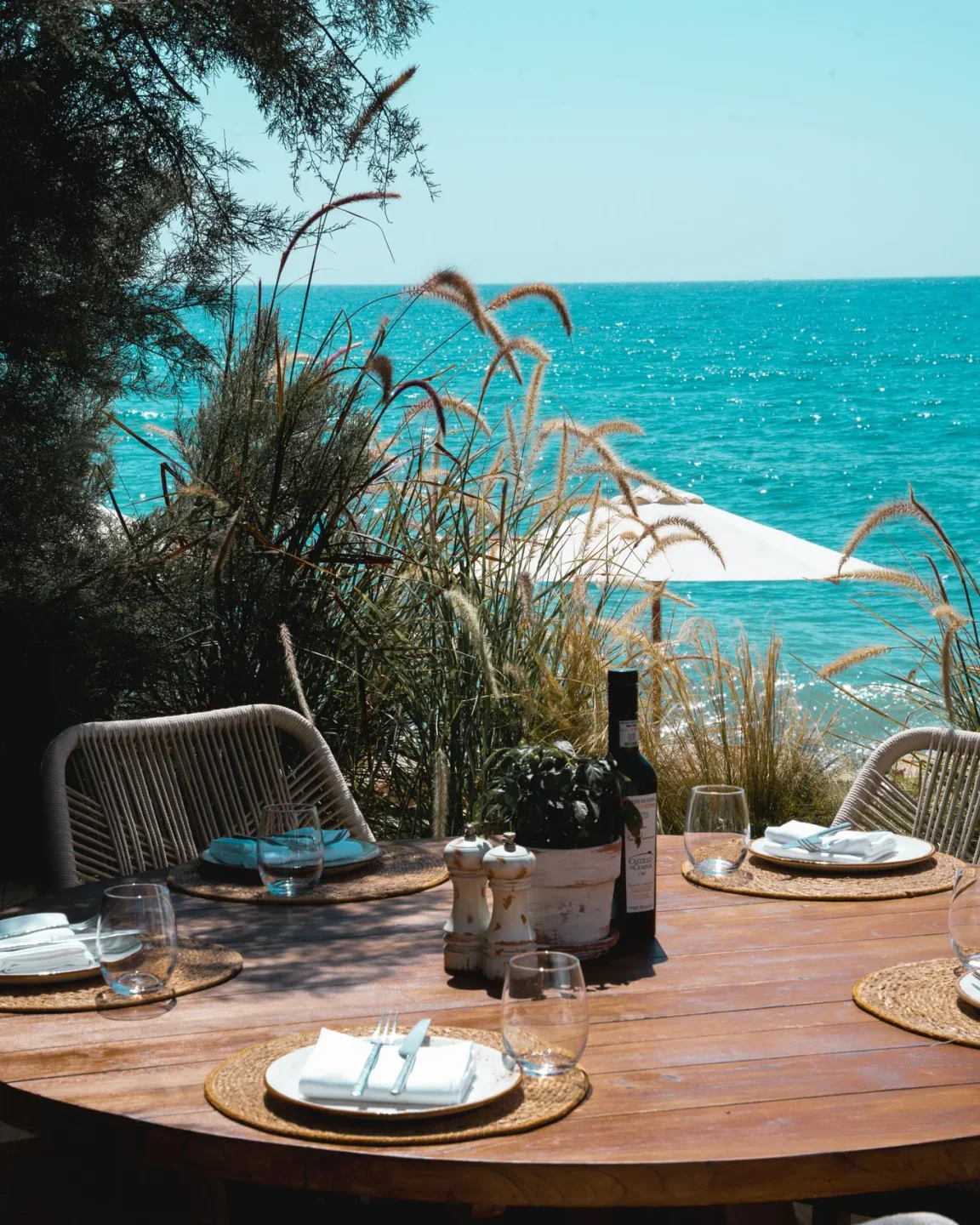 Table set for dining at Chambao restaurant in Marbella with a view of the turquoise Mediterranean Sea.