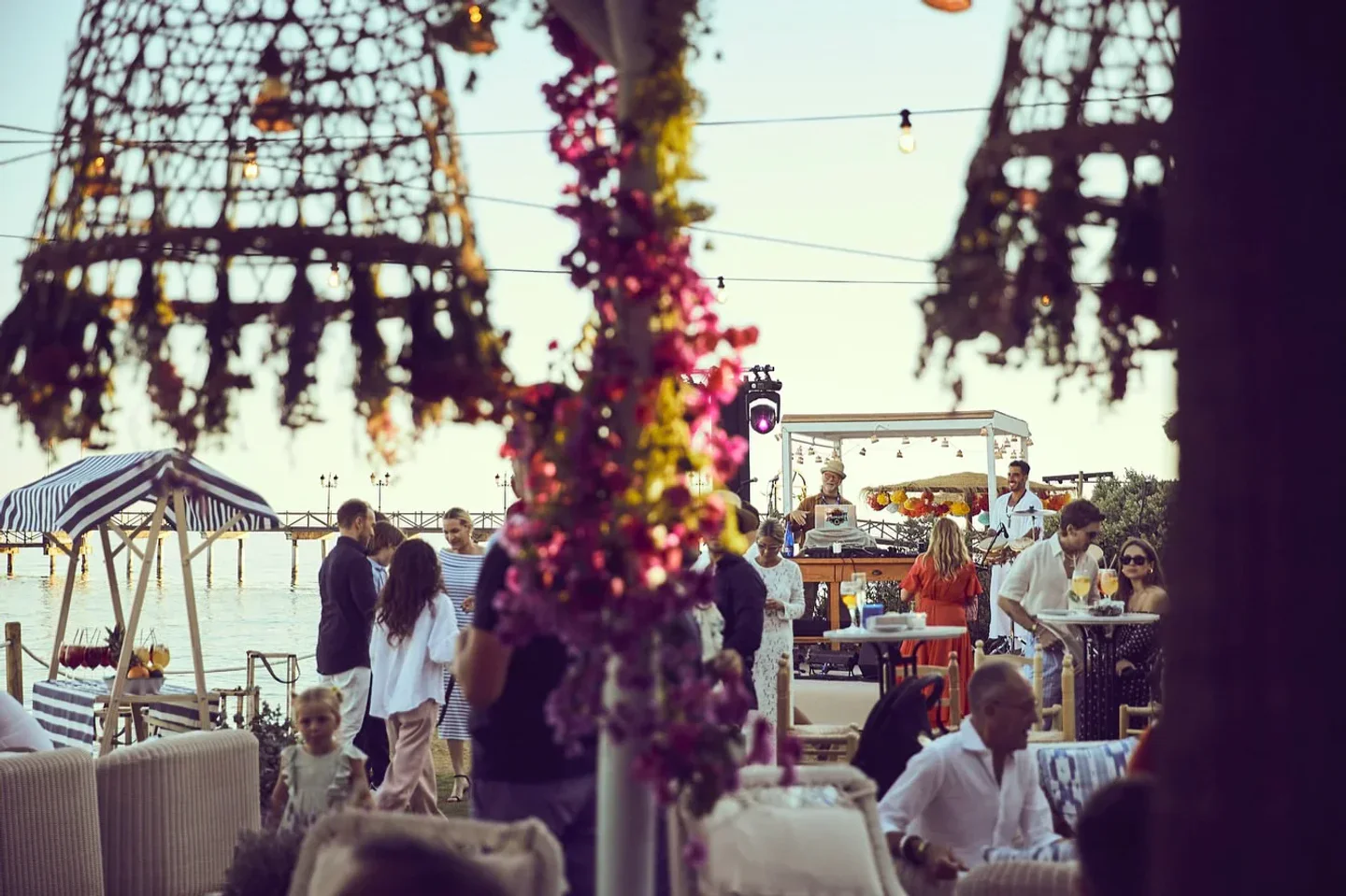 El Patio Marbella Club in Marbella hosts a vibrant outdoor party with a DJ and guests enjoying the seaside atmosphere.