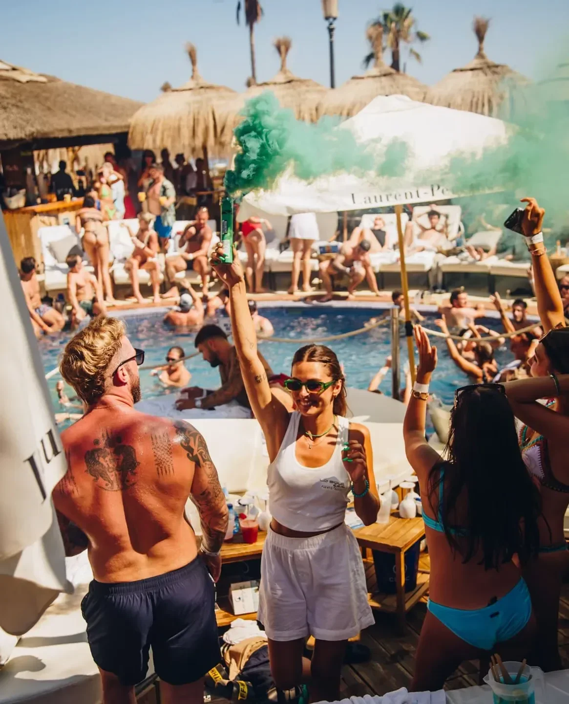 Party at La Sala by the Sea beach club in Marbella, with green smoke and pool fun.