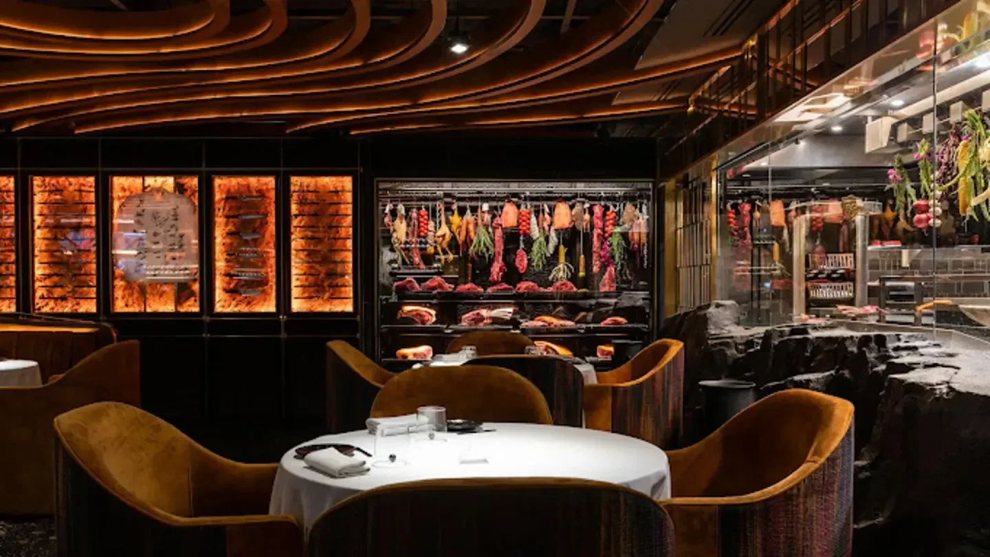 Interior of Len restaurant in Marbella featuring a meat display and elegant seating.