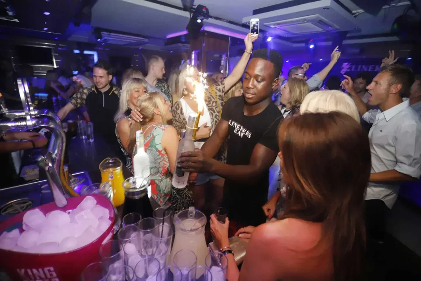 Energetic nightlife scene at Linekers Bar in Marbella, with people enjoying the atmosphere.