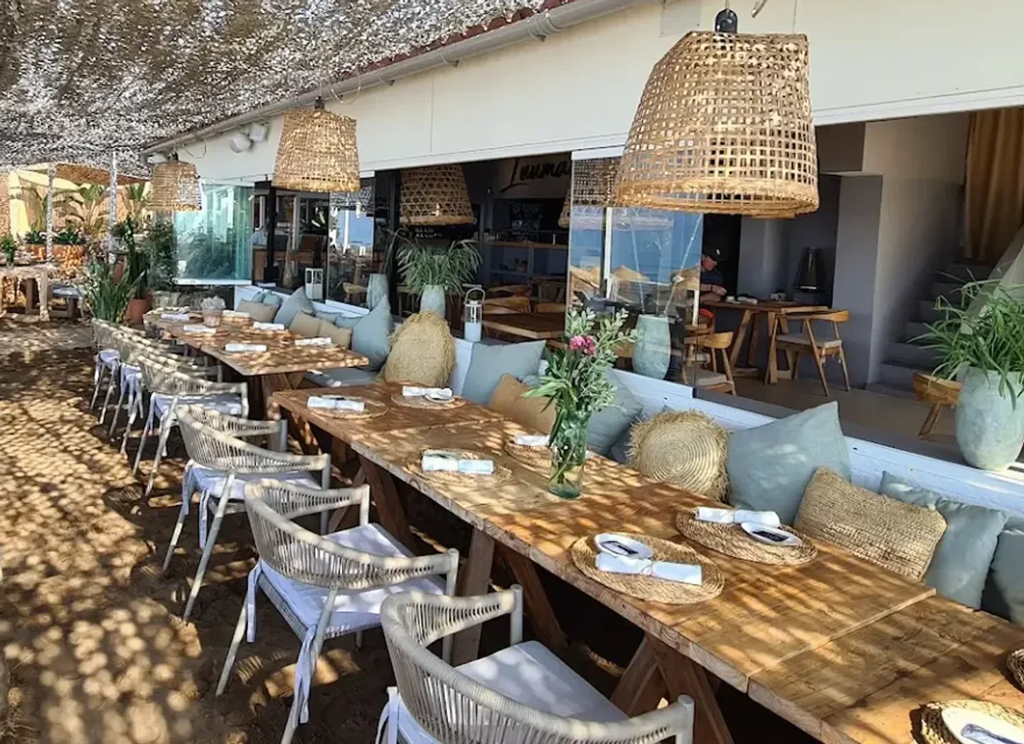 Outdoor dining at Luuma Beach restaurant in Marbella with stylish decor and beach views.