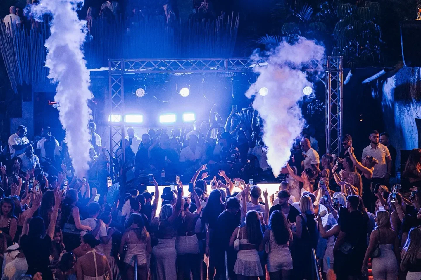 Energetic crowd at Mogli beach club in Marbella, enjoying the music and smoke effects.