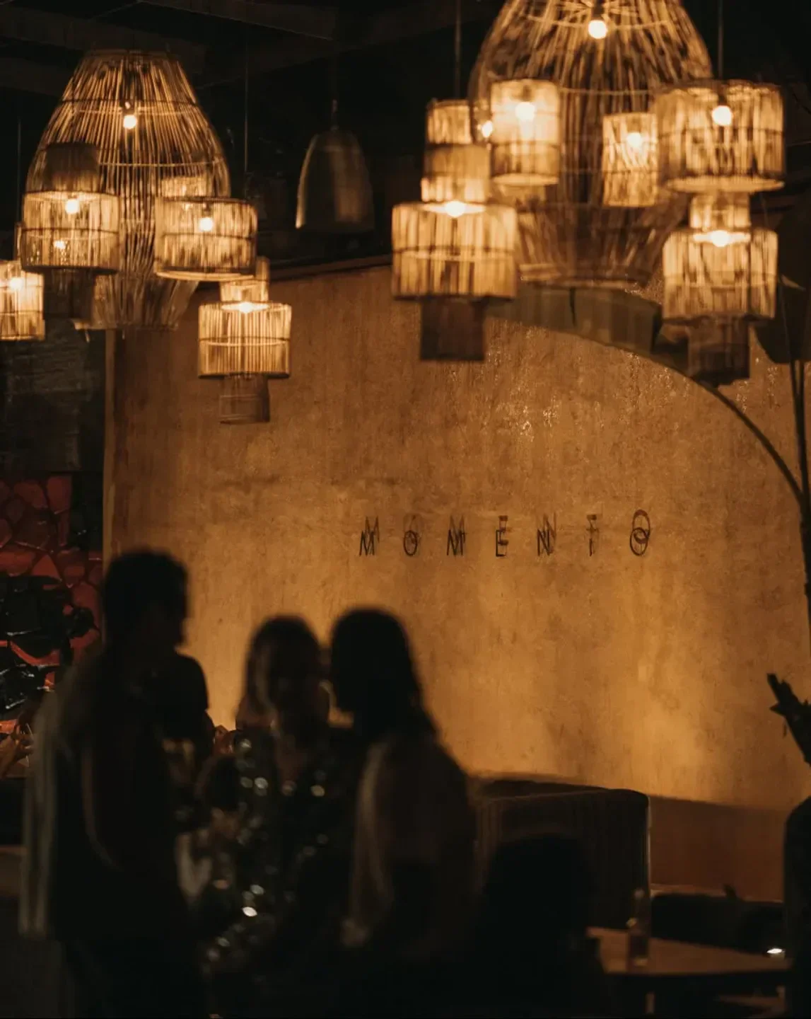 Warm interior of Momento restaurant in Marbella, with ambient lighting and patrons.
