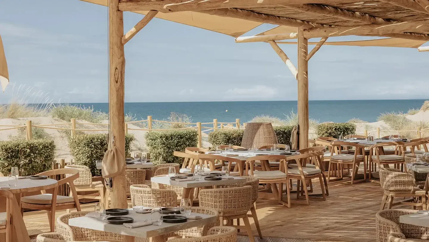 Outdoor dining at Oyana Beach restaurant in Marbella with ocean view and stylish tables.