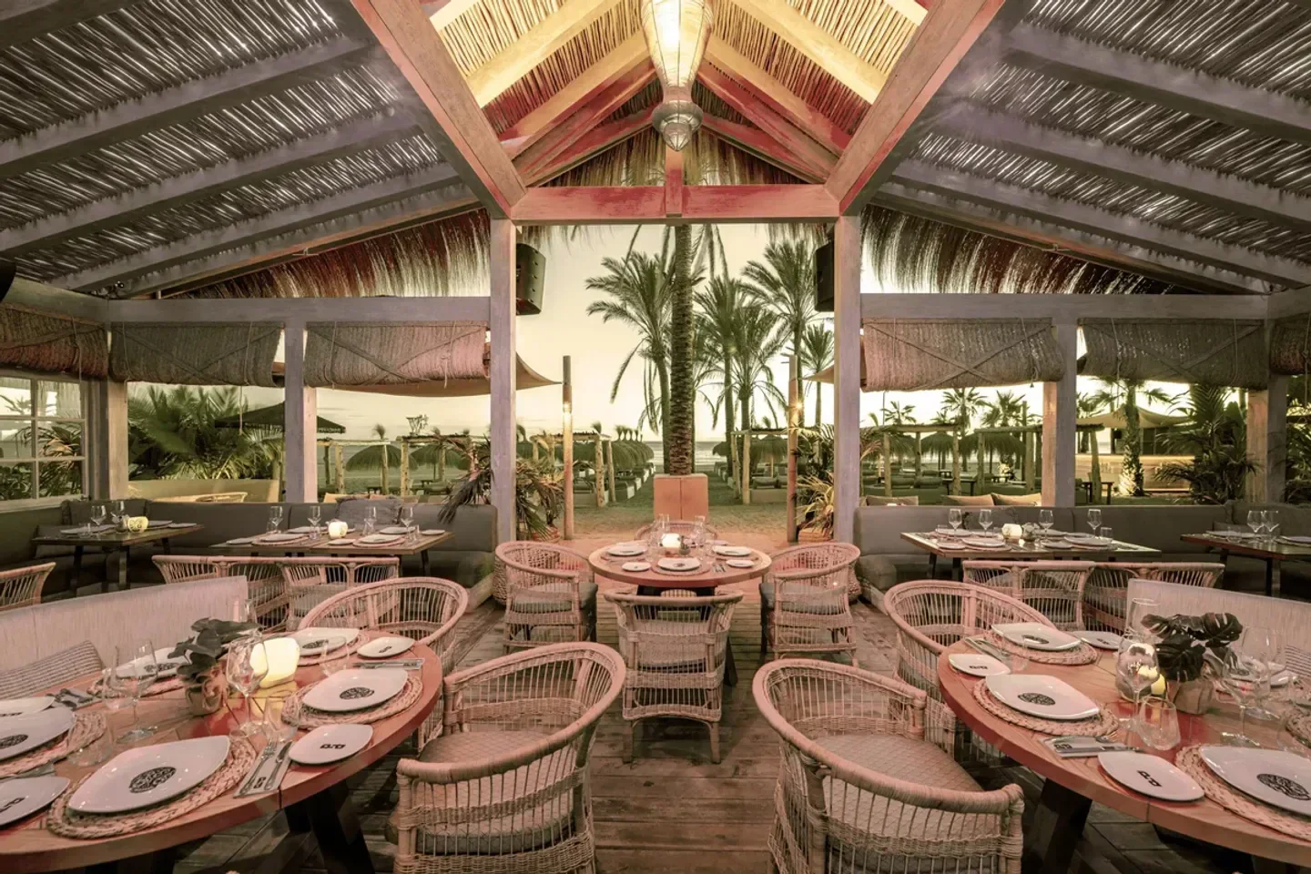 Playa Padre restaurant in Marbella: beachfront dining with stylish decor and palm trees.