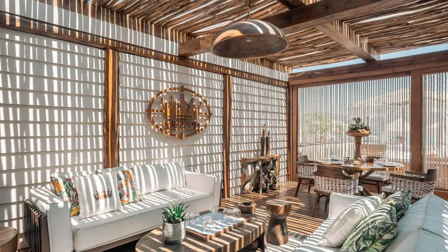 Stylish lounge area at Principote Beach Club in Mykonos, with shadow play and seating.