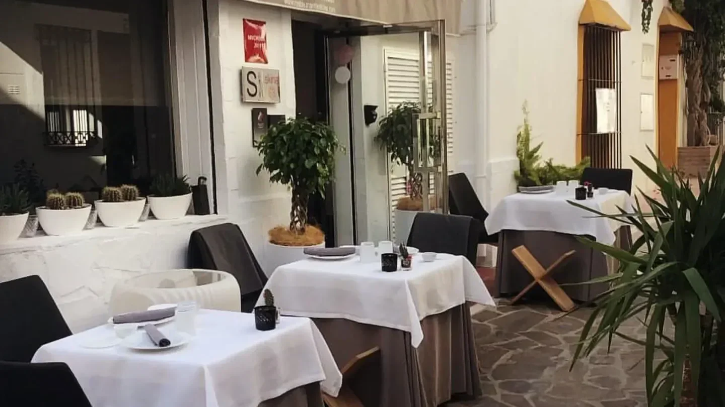 Outdoor dining area at Skina restaurant in Marbella, with tables set for service.