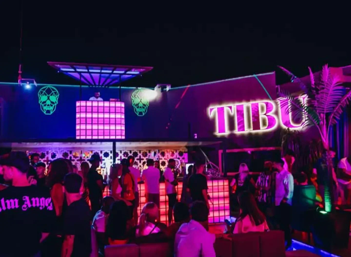 Nightlife scene at Tibu Marbella, with vibrant lights and crowd of people.